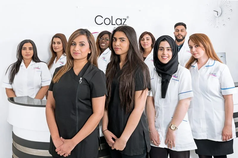 The nine-strong CoLaz Derby team in branded uniform standing in front of the clinic reception sign