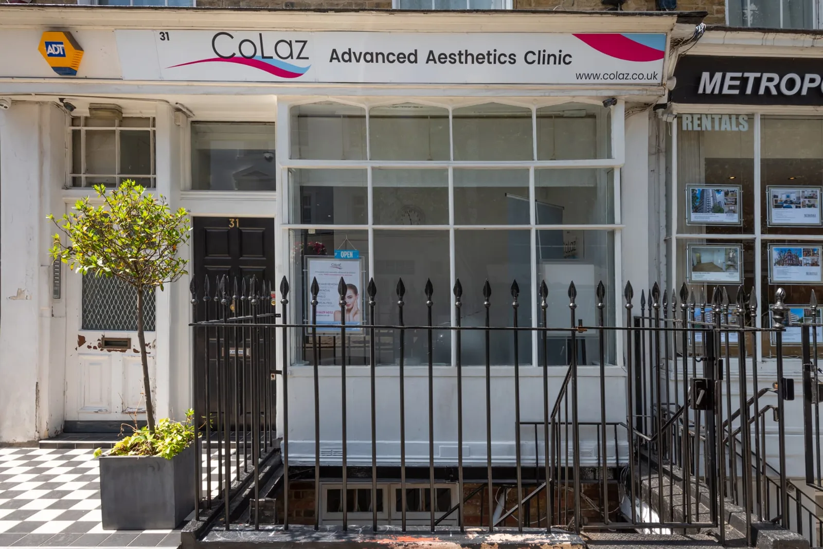 Straight-on view of the CoLaz London Paddington shopfront at 31 Southwick Street, with the CoLaz Advanced Aesthetics Clinic sign across the frontage, the black No. 31 door and a treatment poster in the window