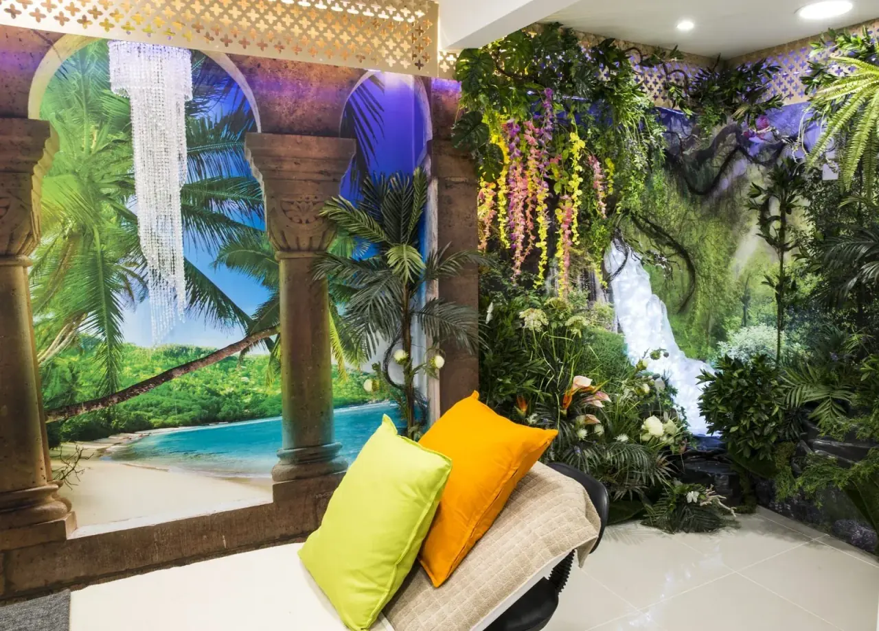 Tropical-themed relaxation lounge at the CoLaz Reading clinic with mural walls, palm decor and a daybed for patients to unwind before treatment