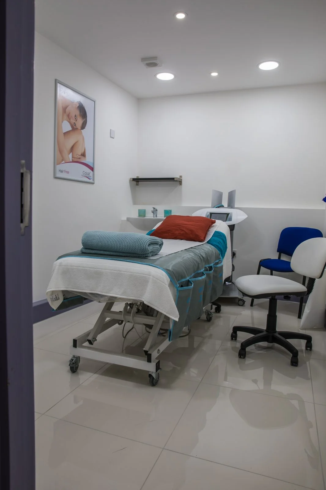 Private treatment room at the CoLaz Wembley clinic set up for a laser hair-removal session, with the device beside the bed