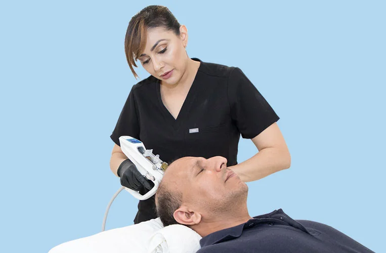 CoLaz clinician using the M8 Gun injector to deliver platelet-rich plasma across a male patient's thinning crown and hairline