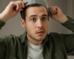 Person wearing a hat while exploring whether hats cause hair loss